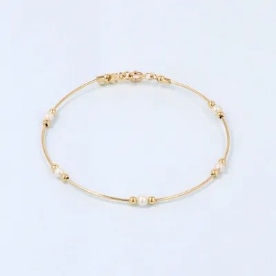 Rigid bracelet in yellow gold with spheres and pearls