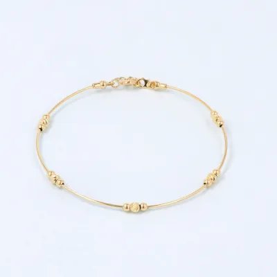 Rigid bracelet in yellow gold with decorated spheres