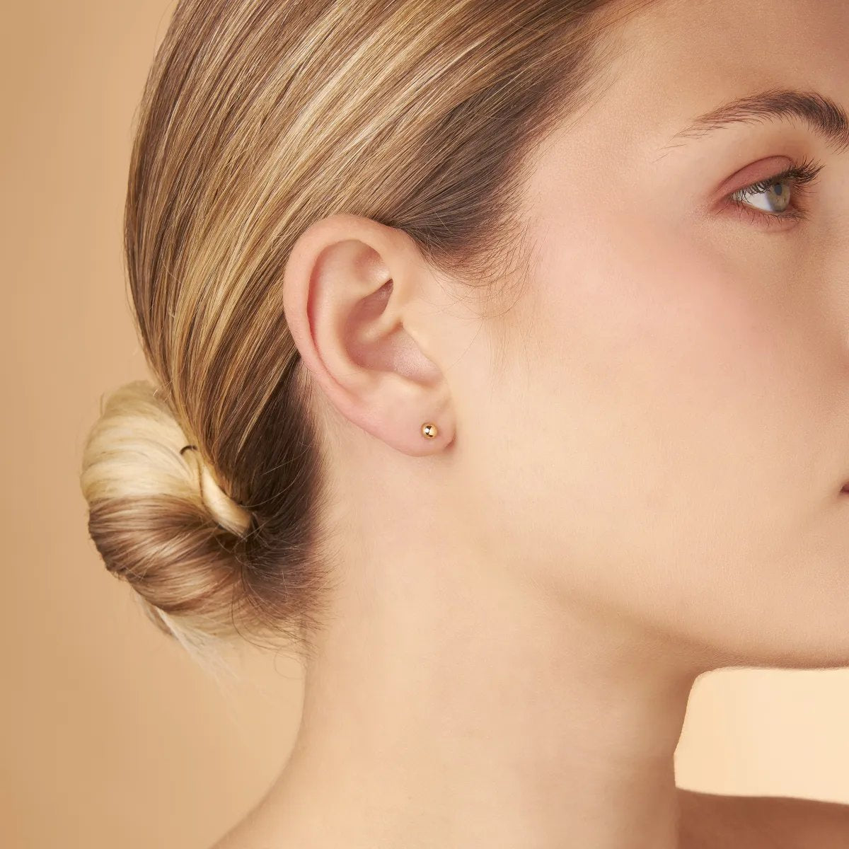 Yellow gold stud earrings in the shape of a sphere