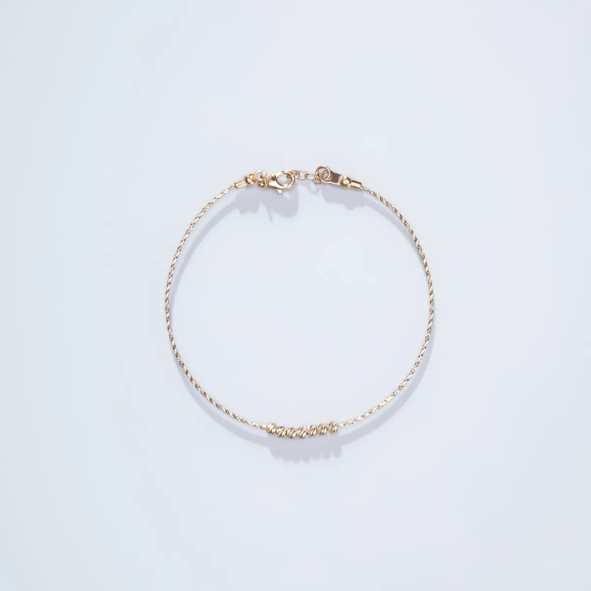 Semi-rigid light bracelet in yellow gold with diamond-cut balls
