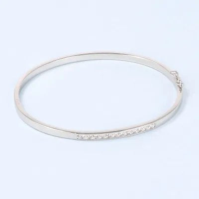 White gold bangle with polish finish and row of zirconia