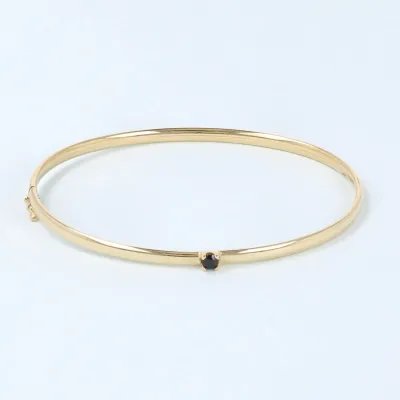 Yellow gold bangle with black zirconia