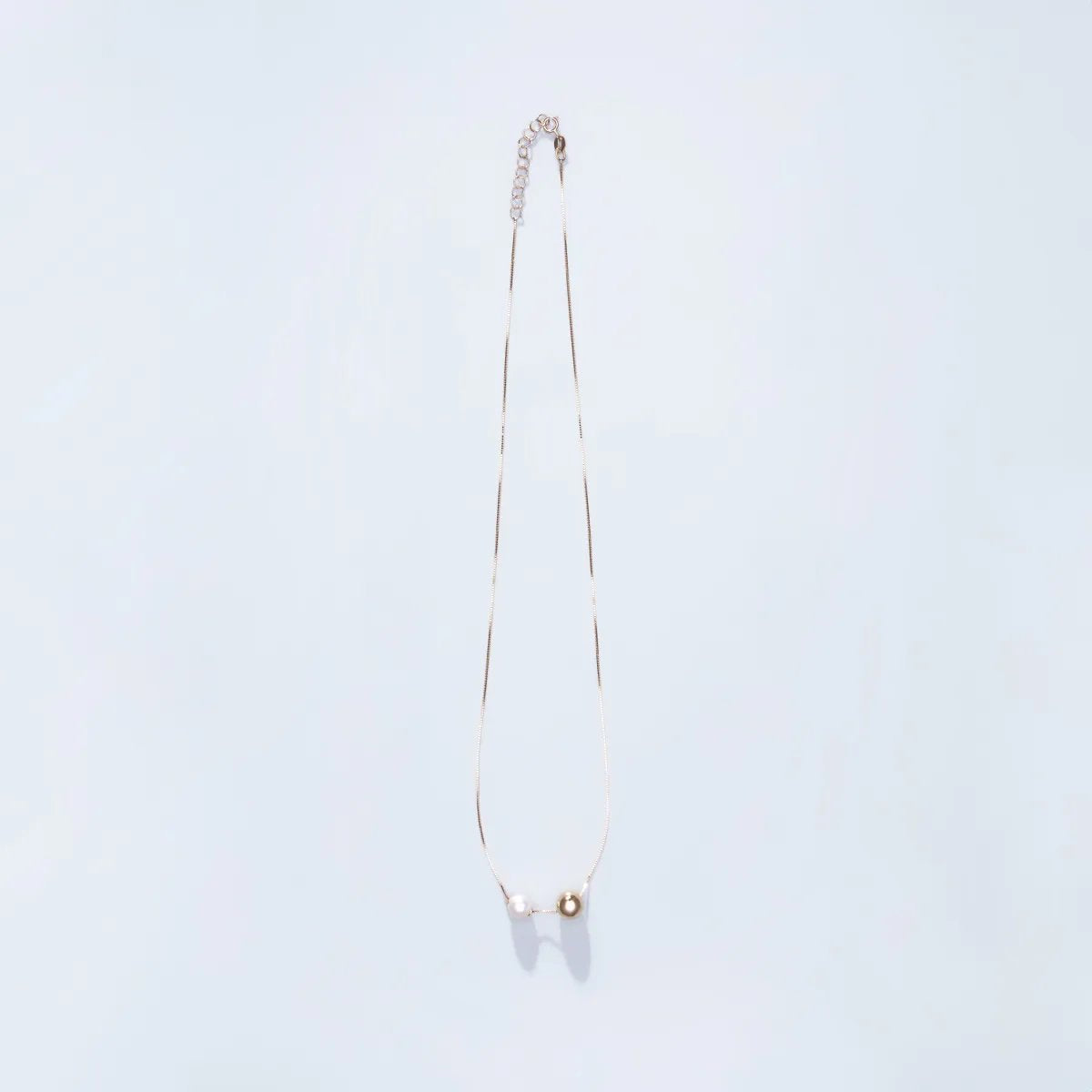 Yellow gold necklace with pearl and sliding ball